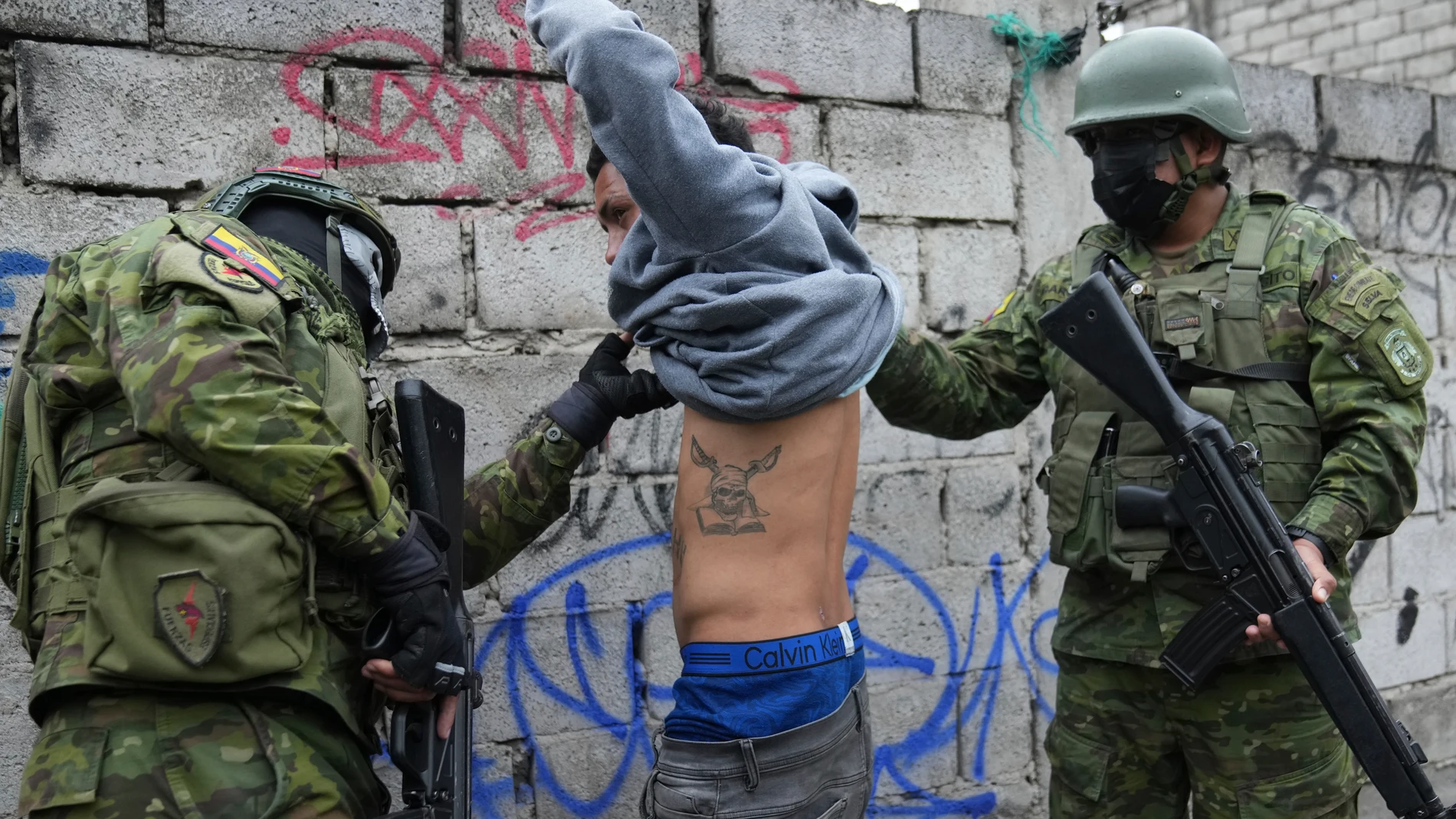 Soldiers briefly detain a youth to check if he has gang-related tattoos as they patrol the south side of Quito, Ecuador, Friday, Jan. 12, 2024, in the wake of the apparent escape of a powerful gang leader from prison. President Daniel Noboa decreed Monday a national state of emergency, a measure that lets authorities suspend people’s rights and mobilize the military. (AP Photo/Dolores Ochoa)