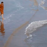 Una persona disfruta del buen tiempo en la playa de la Malvarrosa