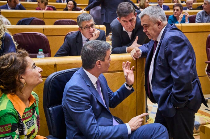 El presidente del Gobierno, Pedro Sánchez, conversa con el diputado socialista Santos Cerdán durante un receso