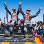 Team Audi Sport's Spanish driver Carlos Sainz (R) and his Spanish co-driver Lucas Cruzof celebrate their victory after crossing the finish line of stage 12 from Yanbu to Yanbu, Saudi Arabia, on January 19, 2024, at the end of the Dakar rally 2024. Veteran Spanish driver Carlos Sainz won on January 19, 2024 the gruelling Dakar Rally for a fourth time on January 19, 2024, becoming at 61 the oldest winner of the race. (Photo by PATRICK HERTZOG / AFP)