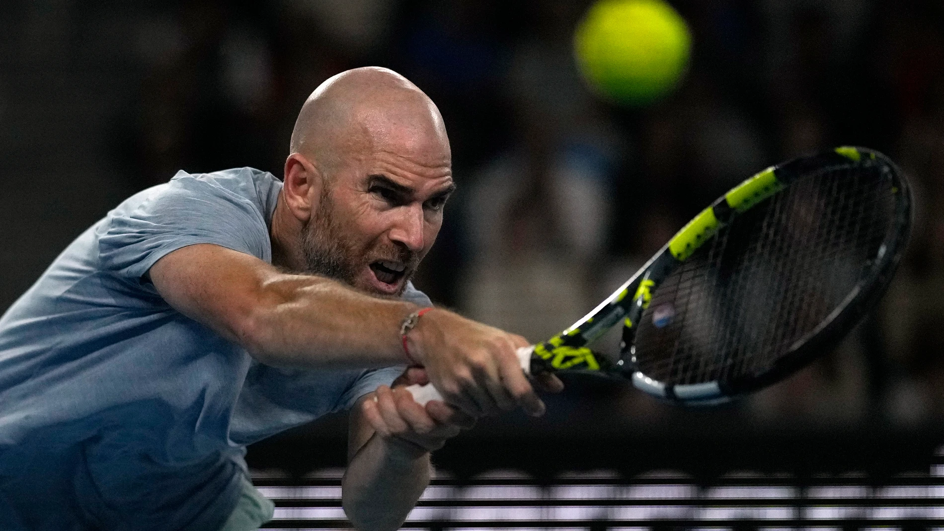Adrian Mannarino of France plays a backhand return to Ben Shelton of the U.S. during their third round match at the Australian Open tennis championships at Melbourne Park, Melbourne, Australia, Friday, Jan. 19, 2024. (AP Photo/Louise Delmotte)