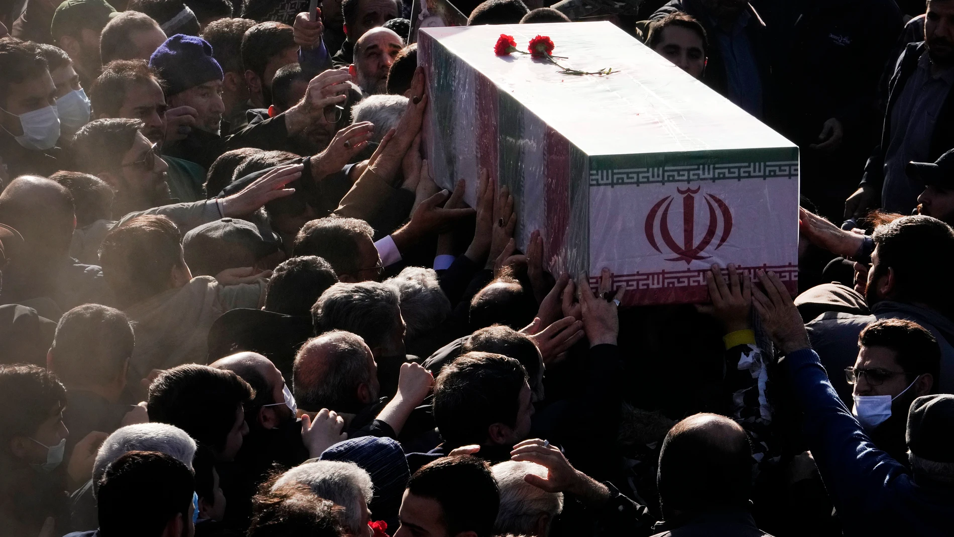 People carry the flag-draped coffin an Iranian Revolutionary Guard member, who was killed in an air strike in Syria, during his funeral ceremony in Tehran, Iran, Monday, Jan. 22, 2024. An Israeli strike on the Syrian capital on Saturday destroyed a building used by the Iranian paramilitary Revolutionary Guard, killing at least five Iranians, Syrian and Iranian state media reported. (AP Photo/Vahid Salemi)