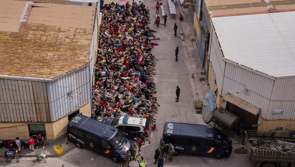 FILE - Unaccompanied minors who crossed into Spain are gathered outside a warehouse used as temporary shelter at the Spanish enclave of Ceuta, near the border of Morocco and Spain, Wednesday, May 19, 2021. Spain's Supreme Court has ruled that Spanish authorities acted illegally when they sent unaccompanied child migrants back to Morocco in 2021. Hundreds of unaccompanied minors were among a surge of some 10,000 people who tried to enter Ceuta, a Spanish enclave in North Africa, by scaling a border fence or swimming around it. (AP Photo/Bernat Armangue, File)