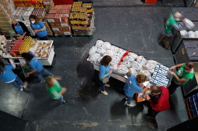  Varias personas recogen alimentos durante un reparto realizado por el Banco de Alimentos en el campo de Mestalla, Valencia.