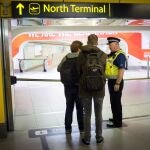 A police officers speaks with travellers at London's Gatwick Airport.