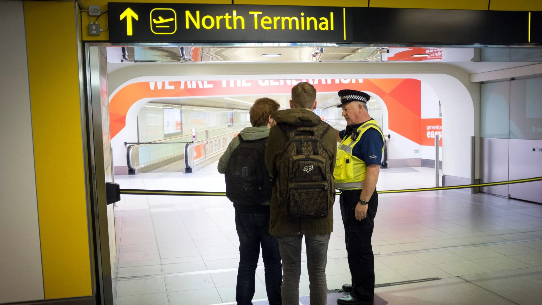 A police officers speaks with travellers at London's Gatwick Airport.