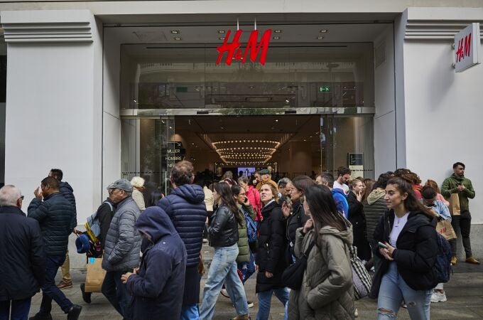 Gente comprando ropa en la cadena multinacional sueca de tiendas de ropa H&M
