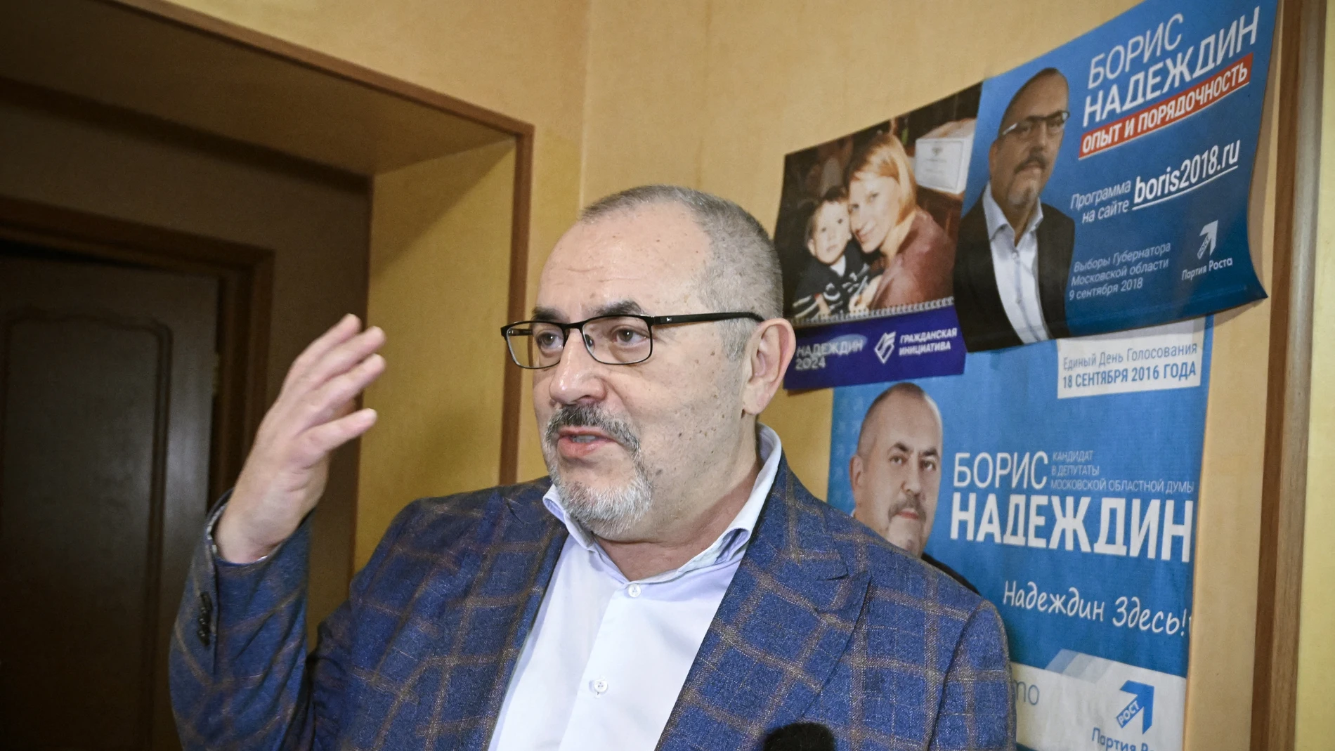 Boris Nadezhdin, the Civic Initiative Party presidential hopeful, talks to an AFP reporter by his campaign posters from past regional elections at his flat in Dolgoprudnyy on January 24, 2024.