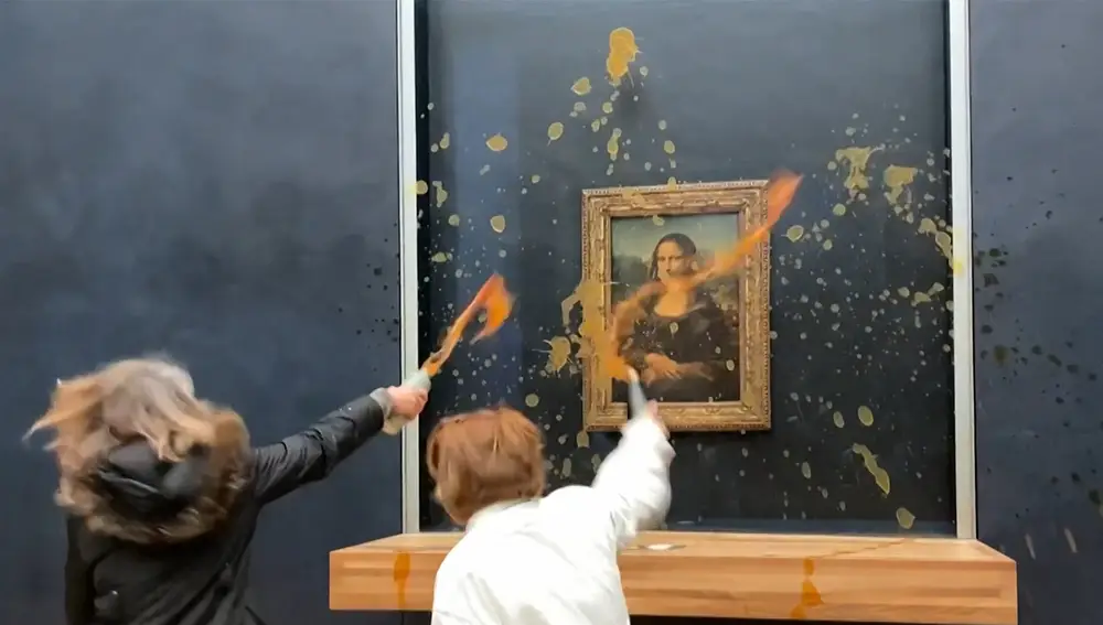 This image grab taken from AFPTV footage shows two environmental activists from the collective dubbed &quot;Riposte Alimentaire&quot; (Food Retaliation) hurling soup at Leonardo Da Vinci's &quot;Mona Lisa&quot; (La Joconde) painting, at the Louvre museum in Paris, on January 28, 2024.