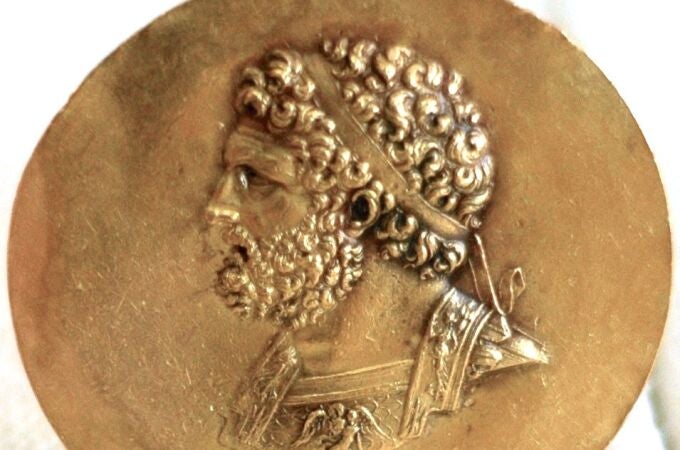 Moneda con la efigie de Filipo II, un hombre que perdió un ojo en la guerra. A la derecha, el arca que se supone que custodia sus restos en Vergina