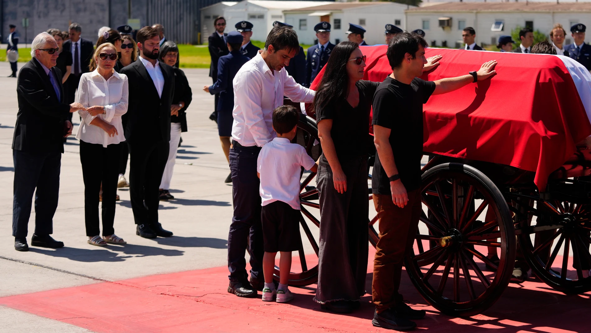 Gabriel Boric, presidente de Chile, y Cecilia Morel, viuda de Sebastián Piñera, reciben su féretro en el aeropuerto de Santiago
