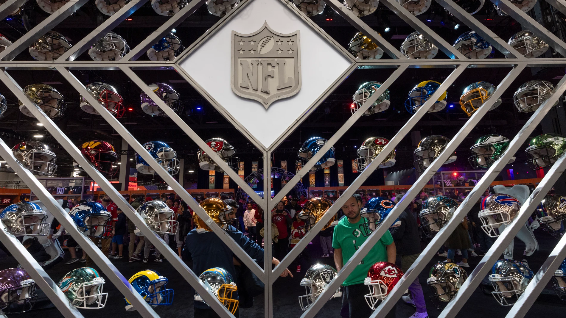 A man looks at a wall of helmets during NFL Experience ahead of Super Bowl 58, Saturday, Feb. 10, 2024, in Las Vegas. The Kansas City Chiefs will play the NFL football game against the San Francisco 49ers Sunday. (AP Photo/Gregory Bull)