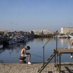 GRAFAND3854. BARBATE (CÁDIZ), 17/07/2023.- Unos jóvenes pescan en el muelle pesquero de Barbate(Cádiz). La falta de pescado en el caladero y el elevado precio del combustible, entre otras circunstancias, han hecho que el acuerdo pesquero entre la UE y Marruecos que expira este lunes no haya sido rentable para los pesqueros de las localidades gaditanas de Barbate y Conil de la Frontera que lo usan para faenar en las aguas vecinas y que hoy se concentran para expresar la crítica situación en la que se encuentra el sector. EFE/Román Ríos