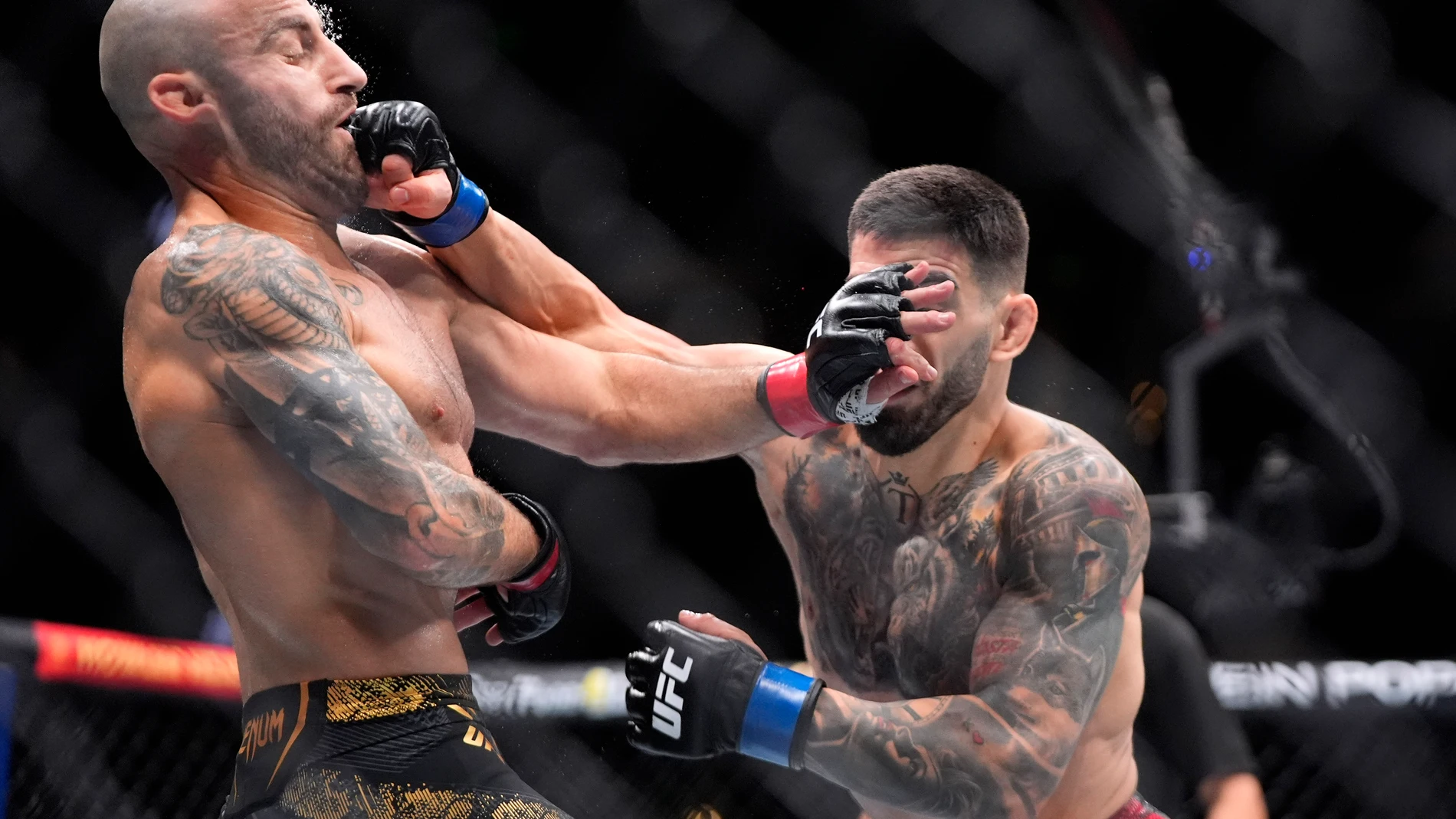 Ilia Topuria, right, connects with Alexander Volanovski during their featherweight bout at the UFC 298 mixed martial arts event Saturday, Feb. 17, 2024, in Anaheim, Calif. (AP Photo/Mark J. Terrill)