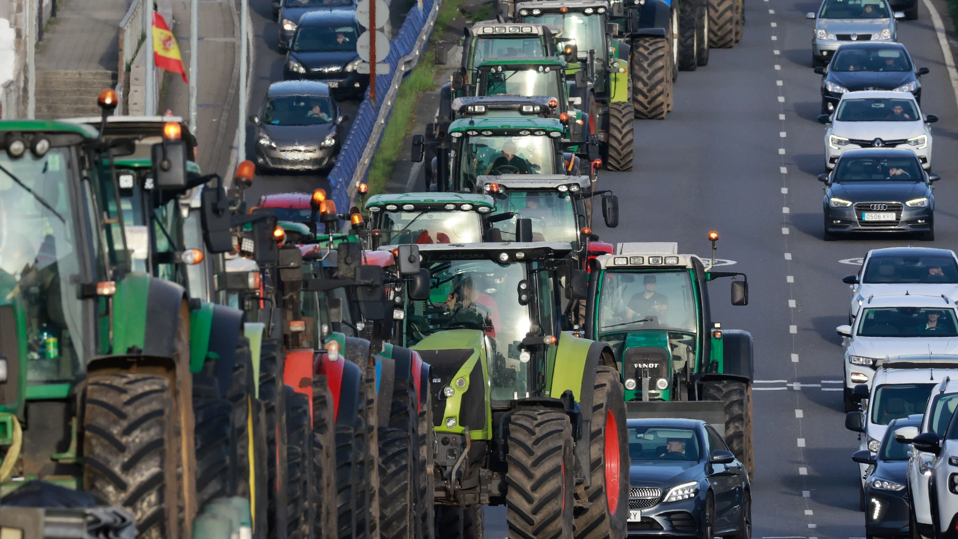 SANTIAGO DE COMPOSTELA, 20/02/2024.- Ganaderos y agricultores ralentizan el tráfico con sus tractores en el centro de Santiago de Compostela esta martes, en el marco de las movilizaciones agrarias convocadas este martes en toda la cornisa cantábrica. Unos sesenta tractores se han concentrado hoy ante la Xunta al estar agricultores y ganaderos en plenas movilizaciones para protestar por la excesiva normativa y burocracia de la UE, que consideran perjudicial para su actividad. EFE/Lavandeira jr