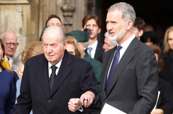Felipe VI ayuda a Don Juan Carlos a la salida de la misa en homenaje a Constantino de Grecia