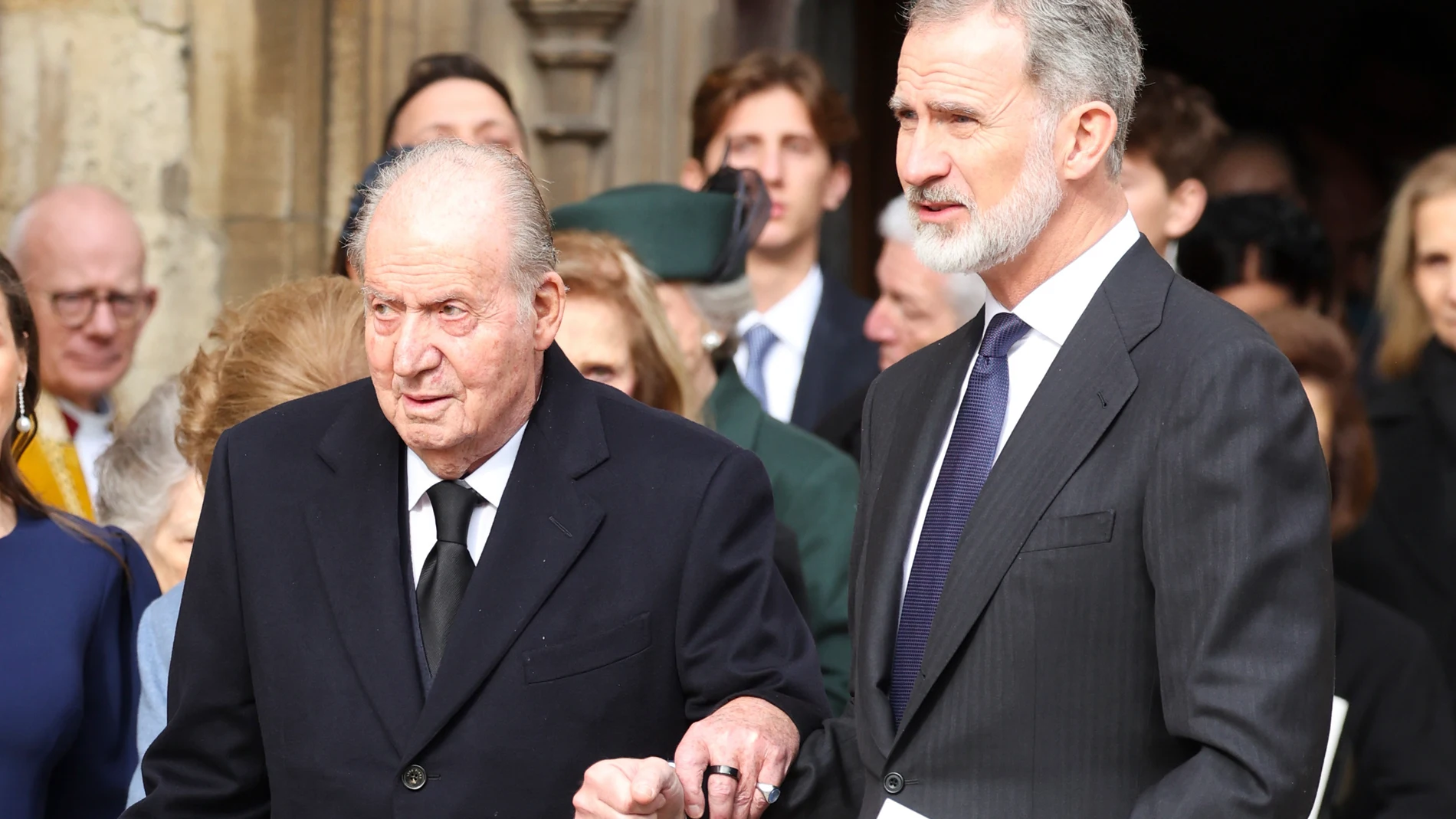 Felipe VI ayuda a Don Juan Carlos a la salida de la misa en homenaje a Constantino de Grecia