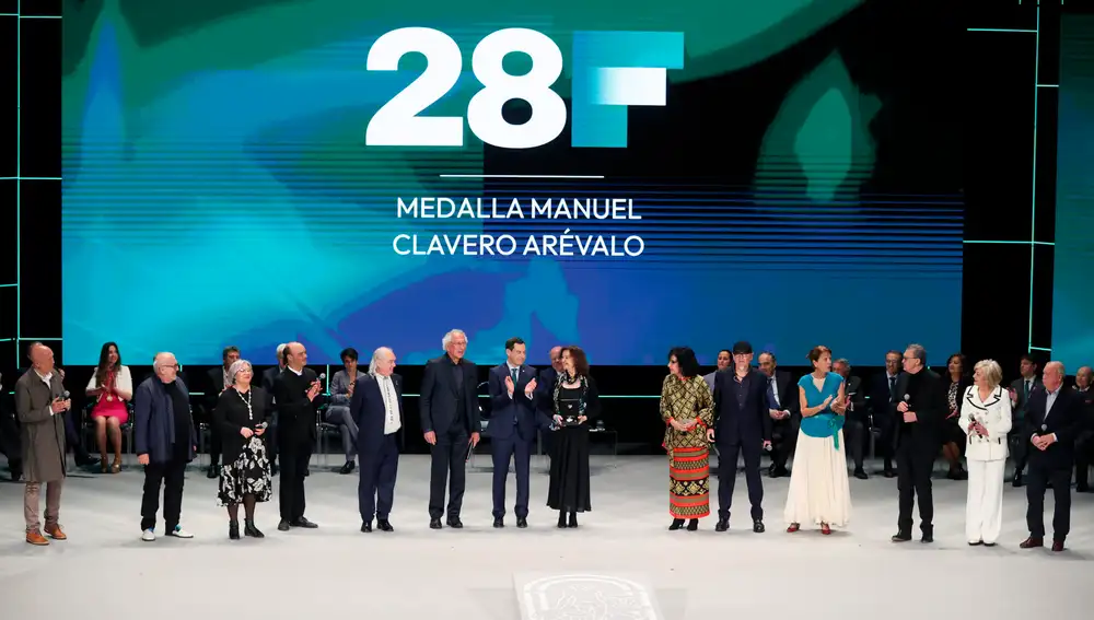 El presidente andaluz, Juanma Moreno (c), tras entregar la Medalla Manuel Clavero Arévalo al grupo musical Jarcha 