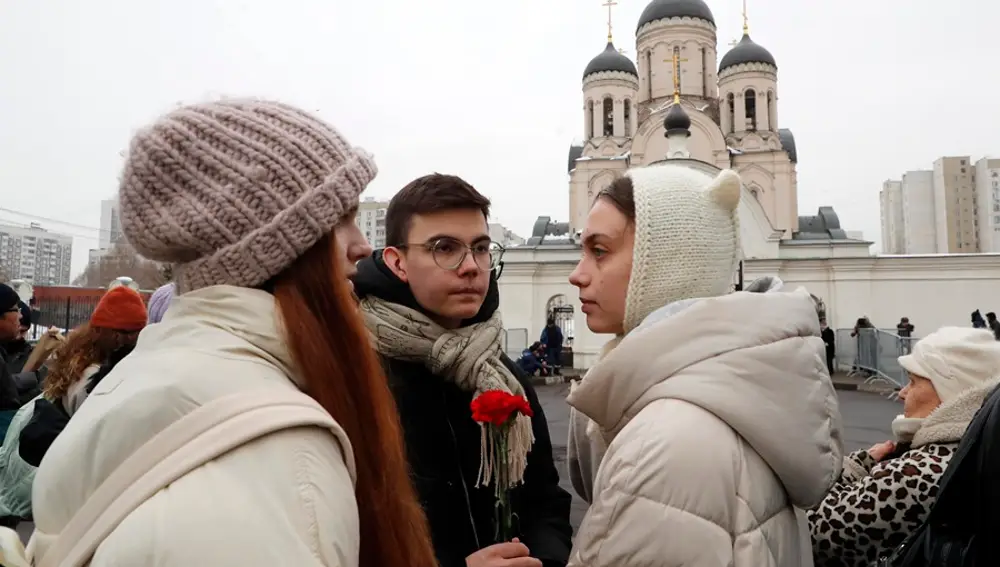 Unos moscovitas espera con un ramo de claves rojos frente a la iglesia en la que se celebra el funeral del opositor ruso Alexei Navalni,