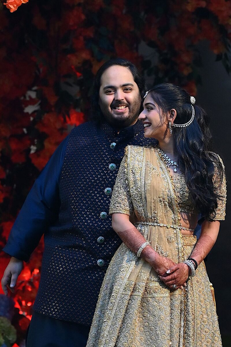Anant Ambani (L), the son of Indian billionaire Mukesh Ambani, poses with his fiancée Radhika Merchant during their engagement ceremony in Mumbai