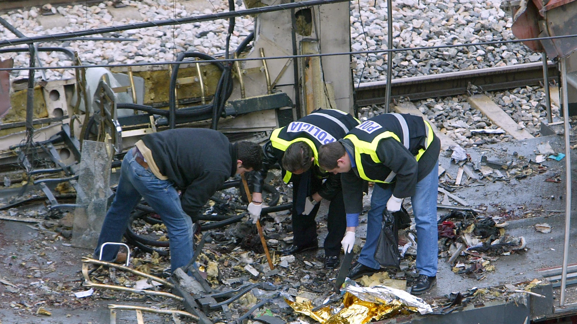 Forensic experts inspect the trains which exploded at the Atocha train station the day before, 12 March 2004 in Madrid. At least 198 people were killed and more than 1400 wounded in bomb attacks on four commuter trains, 11 March 2004.