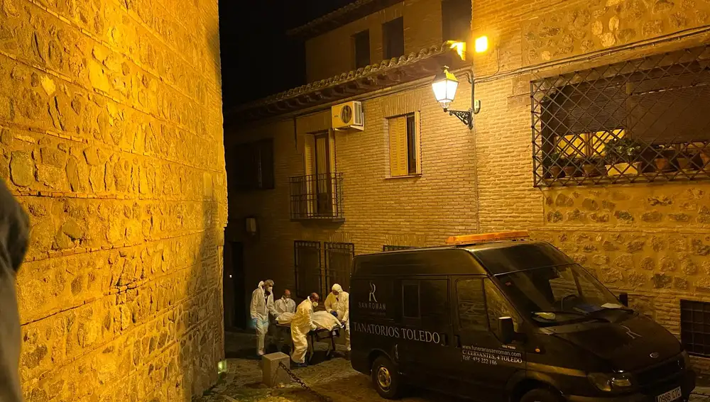 Los forenses retiran uno de los cadáveres hallados en una vivienda de Toledo