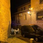 Los forenses retirando uno de los cadáveres hallados en una vivienda de Toledo