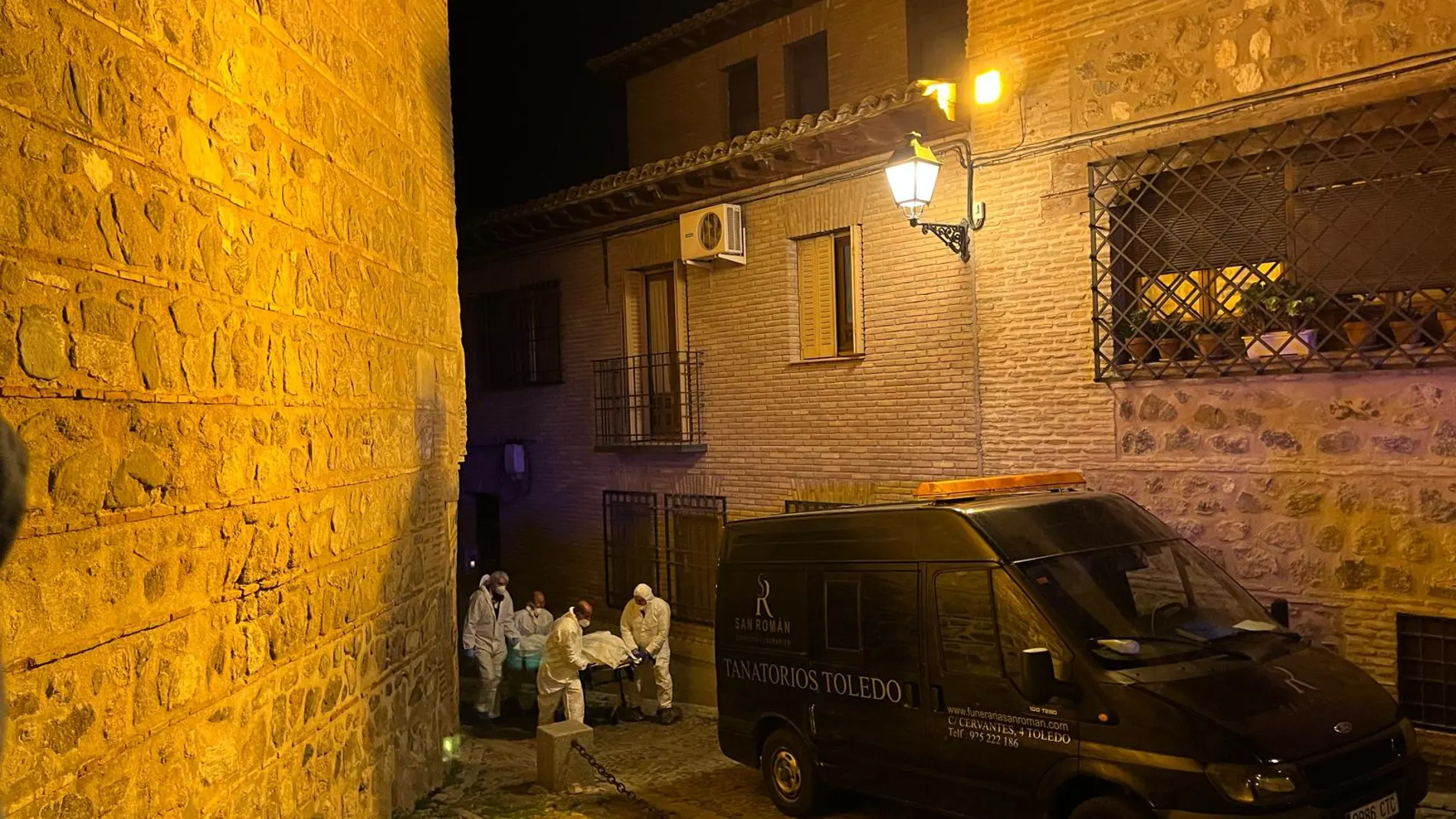 Los forenses retirando uno de los cadáveres hallados en una vivienda de Toledo