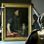 Algunos operarios colocan la primera obra invitada a la Galería de las Colecciones Reales, el «Retrato de Felipe II», pintado por Antonio Moro