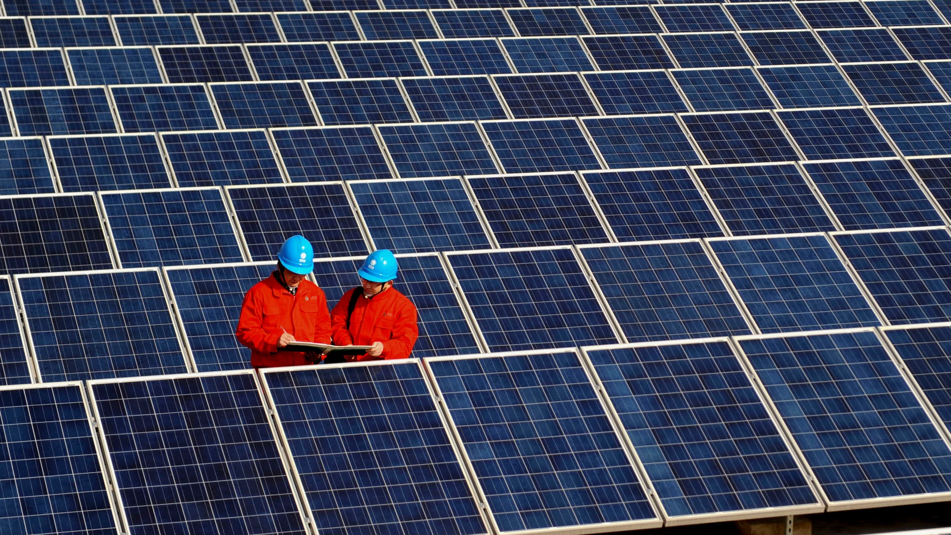 Workers check solar panels at a solar power station on a factory roof in Changxing, eastern China's Zhejiang province. 