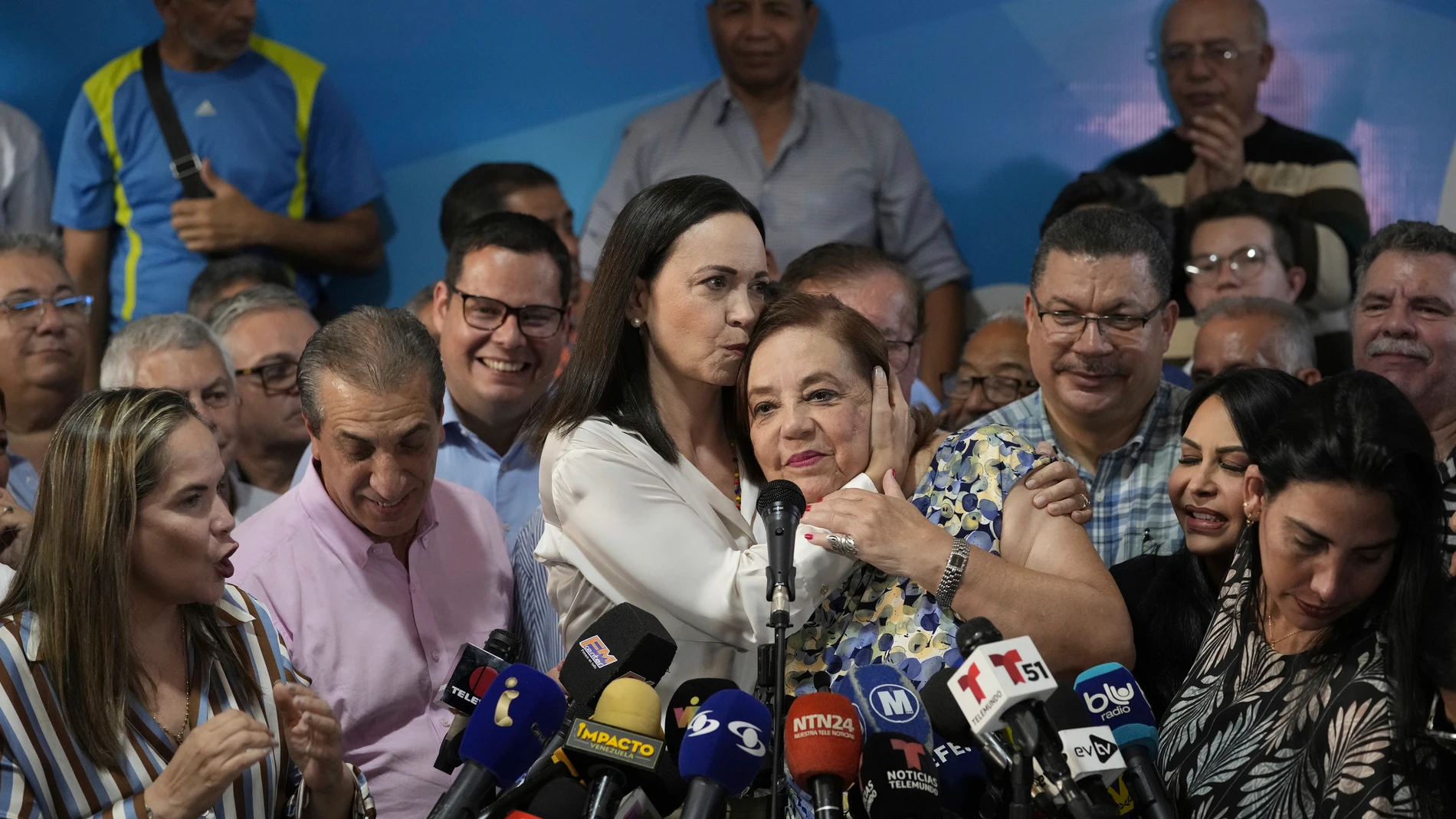 Opposition leader María Corina Machado plants a kiss on Corina Yoris, during a press conference in Caracas, Venezuela, Friday, March 22, 2024. (AP Photo/Ariana Cubillos)
