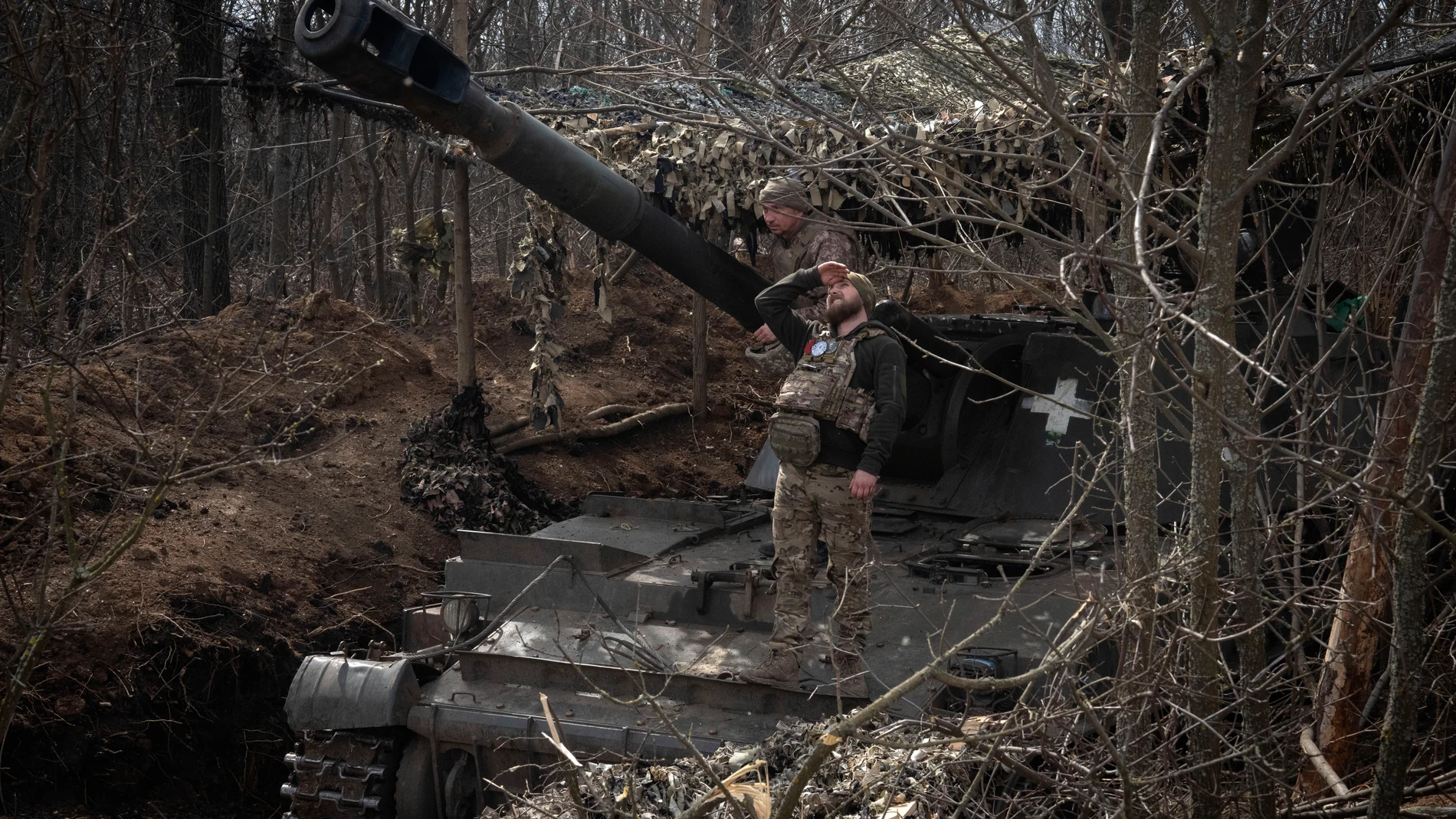A Ukrainian soldier looking for a visual confirmation of drone-free sky, as he prepares to fire 152-mm Self-Propelled Howitzer 2S3, towards Russian positions at the frontline, near Bakhmut, Donetsk region, Ukraine, Monday, March 25, 2024. (AP Photo/Efrem Lukatsky)