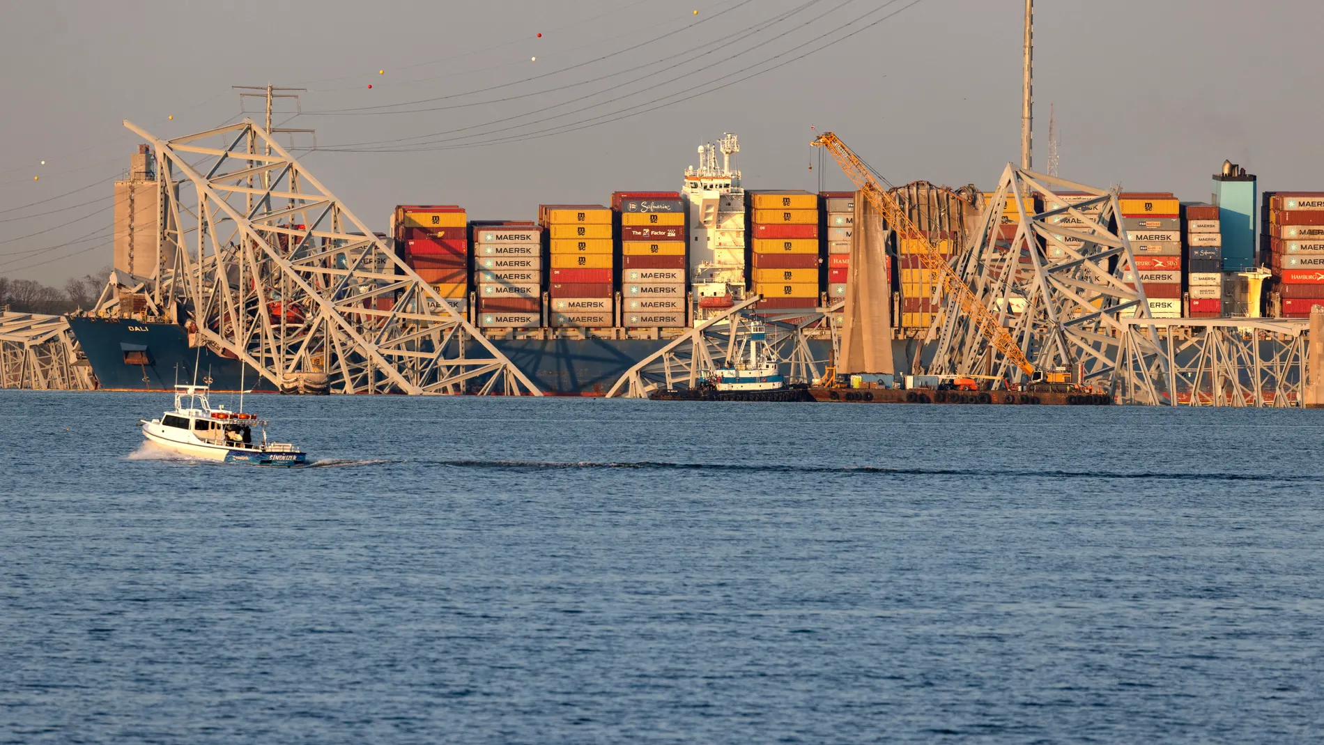 Una grúa trabaja junto al buque de carga Dali, con secciones derribadas del puente Francis Scott Key, en Baltimore