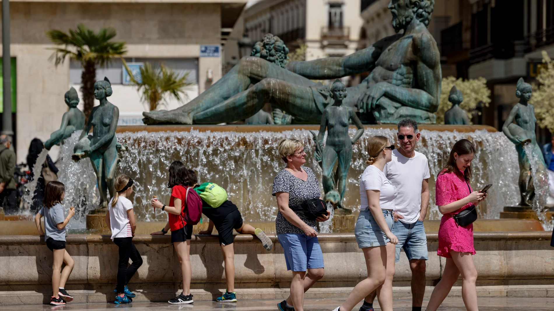 GRAFCVA9674. VALENCIA, 02/04/2024.- Las temperaturas máximas han subido este martes en la Comunitat Valenciana y se han situado entre 22 y 24 grados en algunas localidades. En la imagen un grupo de turistas pasea por la céntrica plaza de la Virgen de Valencia. EFE/Ana Escobar
