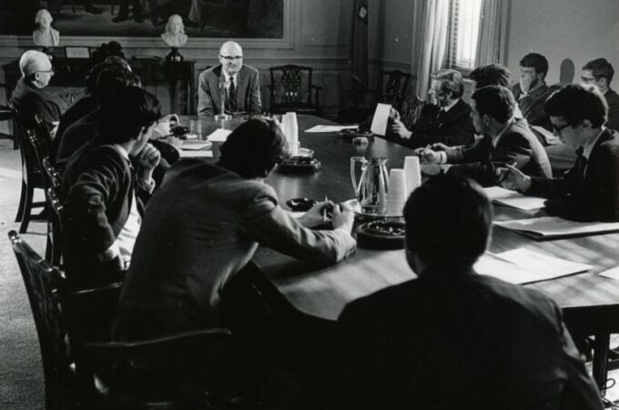 John Barth, al frente de la mesa impartiendo clase en la Universidad