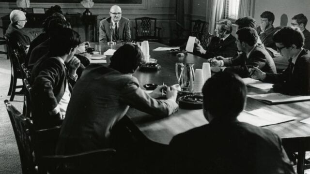 John Barth, al frente de la mesa impartiendo clase en la Universidad