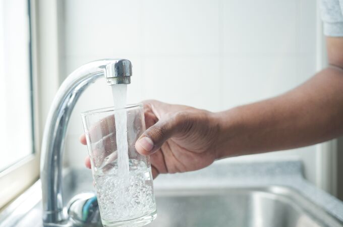 Imagen de una persona llenando un vaso con agua del grifo