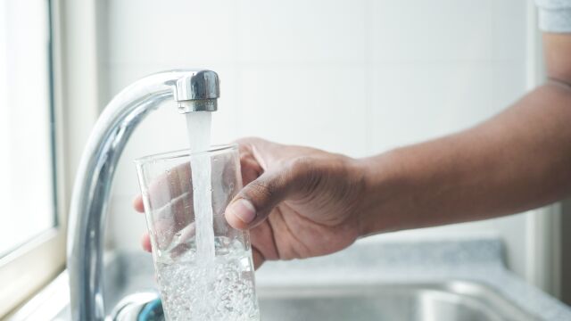 Imagen de una persona llenando un vaso con agua del grifo