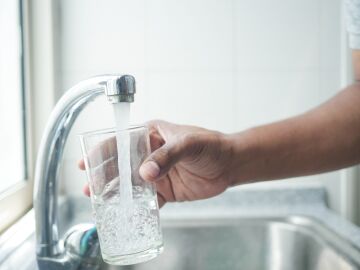 Imagen de una persona llenando un vaso con agua del grifo