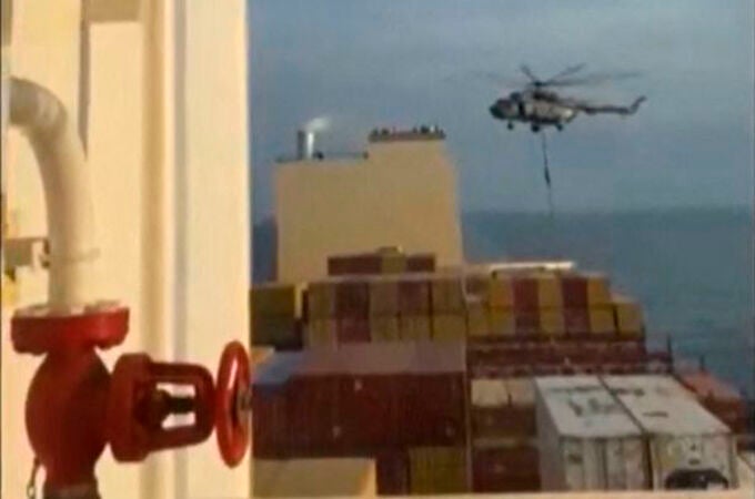 This image grab taken from a UGC video posted on social media on April 13, 2024 shows Iran's Revolutionary Guards rappelling down onto a container ship named, MSC Aries, near the Strait of Hormuz. - Iran's Revolutionary Guards on Saturday seized a container ship "related to the Zionist regime (Israel) in the Gulf," 