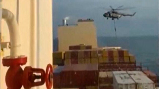 This image grab taken from a UGC video posted on social media on April 13, 2024 shows Iran's Revolutionary Guards rappelling down onto a container ship named, MSC Aries, near the Strait of Hormuz. - Iran's Revolutionary Guards on Saturday seized a container ship "related to the Zionist regime (Israel) in the Gulf," 