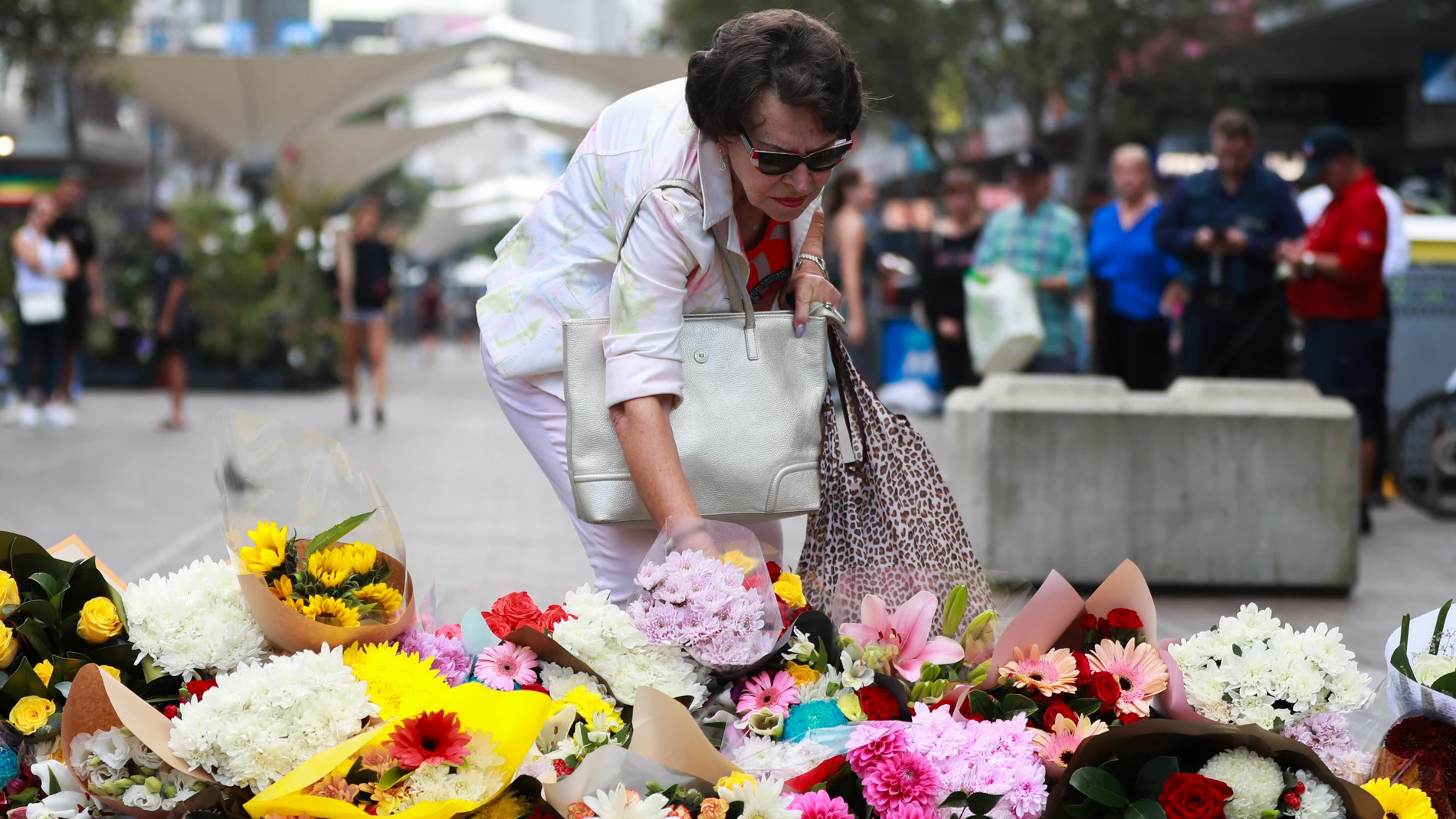 SYDNEY, April 14, 2024 -- A woman lays flowers outside the Westfield Shopping Centre at Bondi Junction in Sydney, Australia, April 14, 2024. Australian police on Sunday identified the perpetrator of a Sydney shopping centre stabbing that killed six people, saying no intelligence would suggest the attack was driven by ideology. The offender in the Saturday afternoon attack at Westfield Shopping Centre at Bondi Junction was 40-year-old Joel Cauchi from Queensland, New South Wales (NSW) Poli...