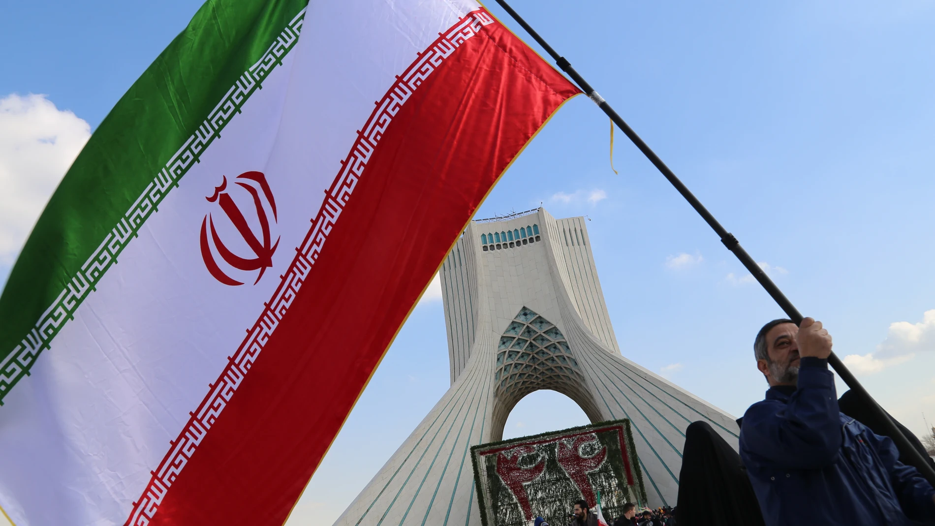 February 11, 2023, Tehran, Tehran, Iran: An Iranian man hold an Iranian flag next to Azadi (freedom) tower during the annual rally commemorating Iran's 1979 Islamic Revolution in Tehran, Iran, February 11, 2023. Iran on Saturday celebrated the 44th anniversary of the 1979 Islamic Revolution amid nationwide anti-government protests and heightened tensions with the West. Tens of thousands of Iranians hit the streets in Tehran and other cities today to mark the 44th anniversary of the Islamic re...
