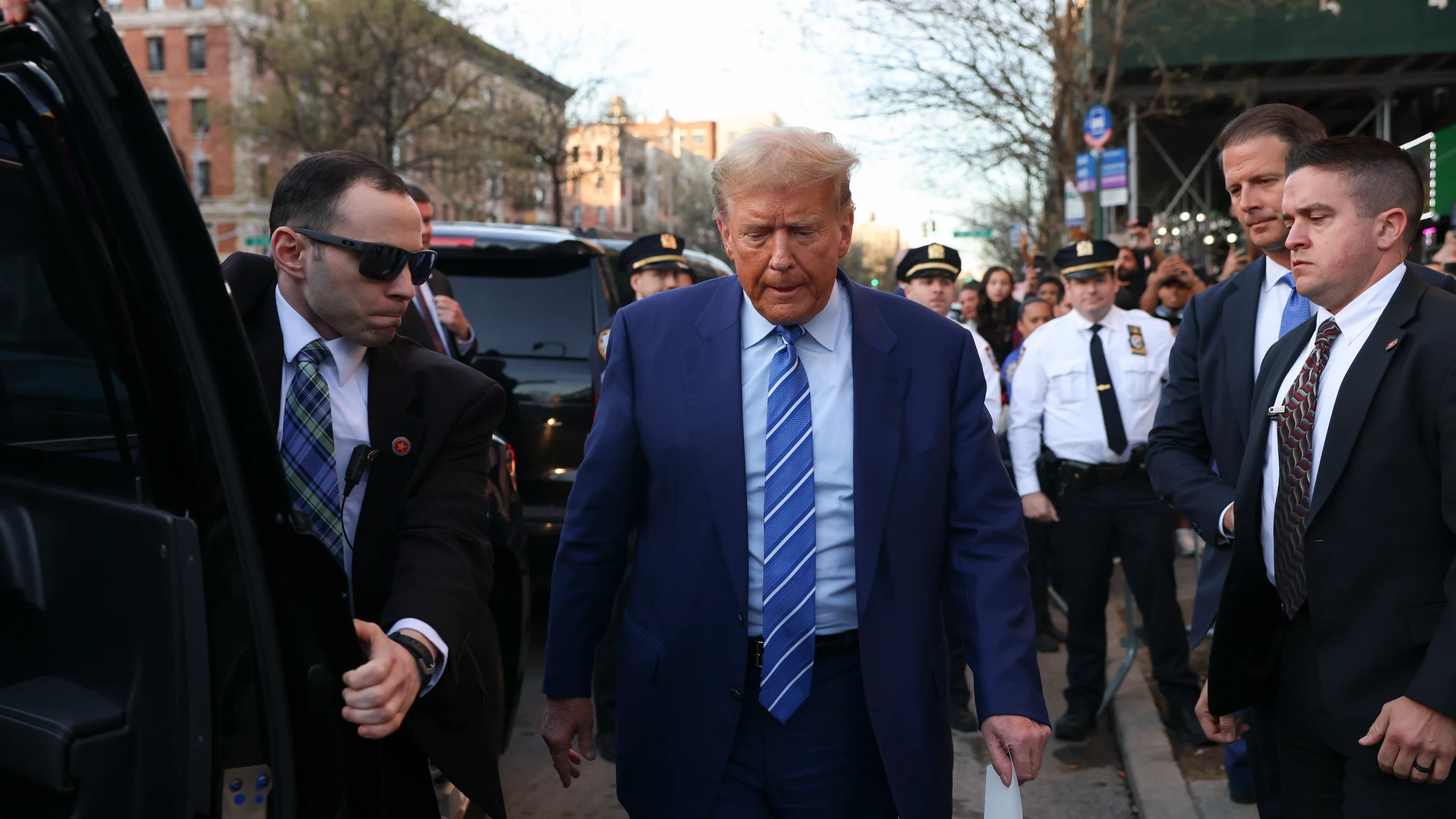 Former president Donald Trump, returns to his car after visiting a bodega, Tuesday, April 16, 2024, who's owner was attacked last year in New York. Fresh from a Manhattan courtroom, Donald Trump visited a New York bodega where a man was stabbed to death, a stark pivot for the former president as he juggles being a criminal defendant and the Republican challenger intent on blaming President Joe Biden for crime. Alba's attorney, Rich Cardinale, second from left, and Fransisco Marte, president o...