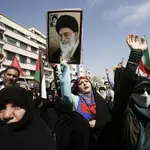 An Iranian woman (C) holds up a portrait of the Iranian supreme leader Ayatollah Ali Khamenei as others wave Iranian and Palestinian flags during an anti-Israel rally in Tehran, Iran, 19 April 2024. Iranian state media reported that three aerial objects were destroyed by air defense systems over the central city of Isfahan early morning on 19 April. 