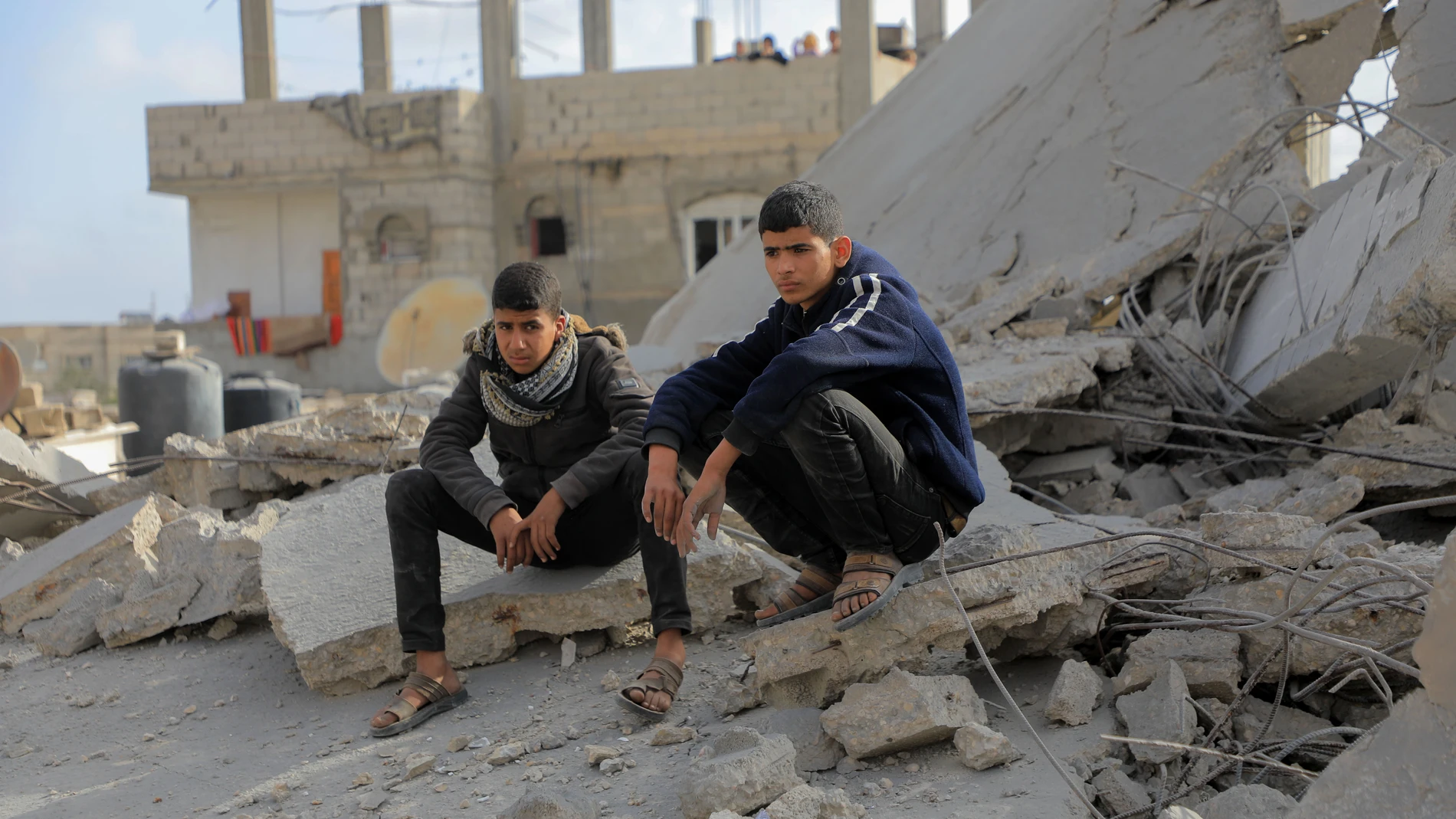 GAZA, April 22, 2024 -- Two men sit among rubble of destroyed buildings after an Israeli airstrike in the southern Gaza Strip city of Rafah, April 21, 2024. The Palestinian death toll from ongoing Israeli attacks on the Gaza Strip has risen to 34,097, the Hamas-run Health Ministry said in a statement on Sunday.21/04/2024