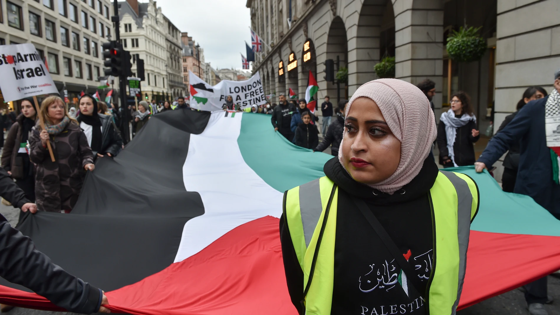 Pro-Palestinian protesters hold a giant flag as they take part in a demonstration in London, Saturday, April 27, 2024. (AP Photo/Thomas Krych)