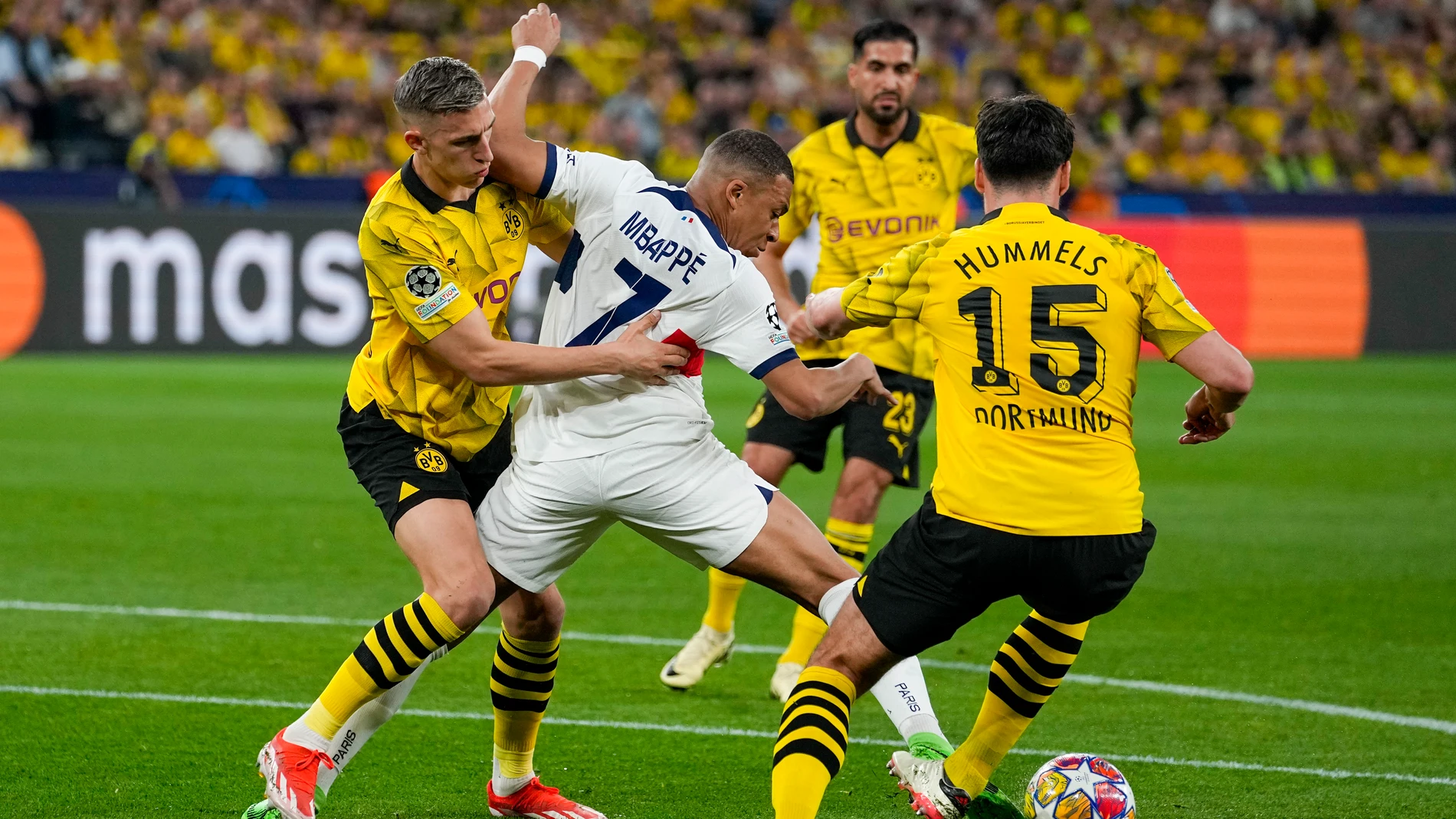 PSG's Kylian Mbappe, center, is challenged by Dortmund's Nico Schlotterbeck, left, and Mats Hummels during the Champions League semifinal first leg soccer match between Borussia Dortmund and Paris Saint-Germain at the Signal-Iduna Park in Dortmund, Germany, Wednesday, May 1, 2024. (AP Photo/Martin Meissner)