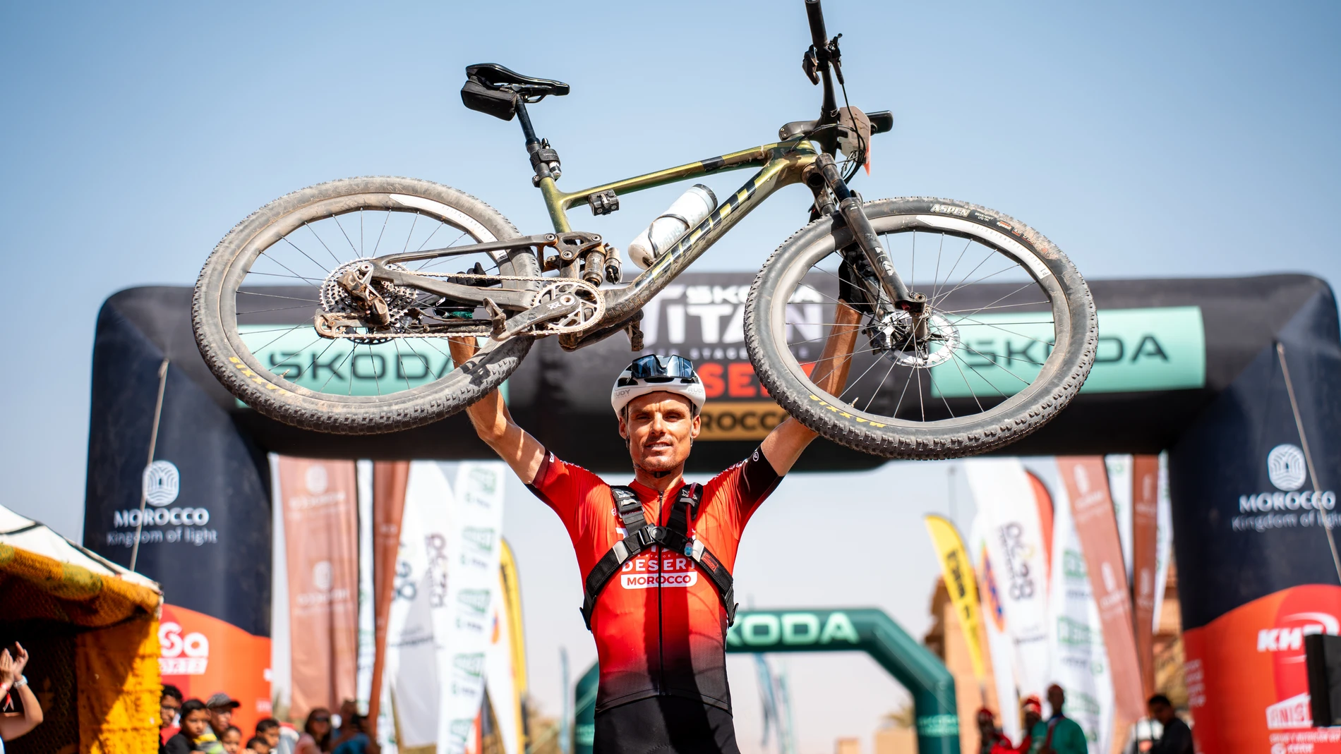 Luis León Sánchez levanta su bicicleta como ganador de la Titan Desert