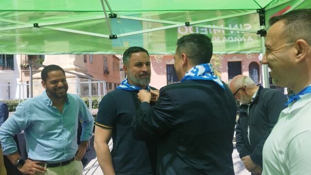 El líder de Vox, Santiago Abascal, se coloca el pañuelo de la Festa Major de Badalona (Barcelona) antes de atender a los medios